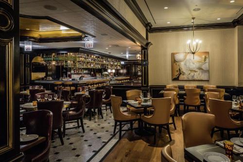 a restaurant with tables and chairs and a bar at Waldorf Astoria Chicago in Chicago