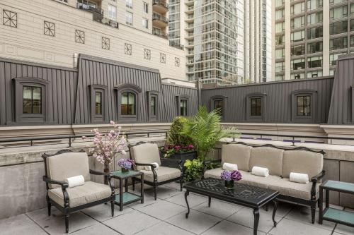 a rooftop patio with chairs and tables and buildings at Waldorf Astoria Chicago in Chicago