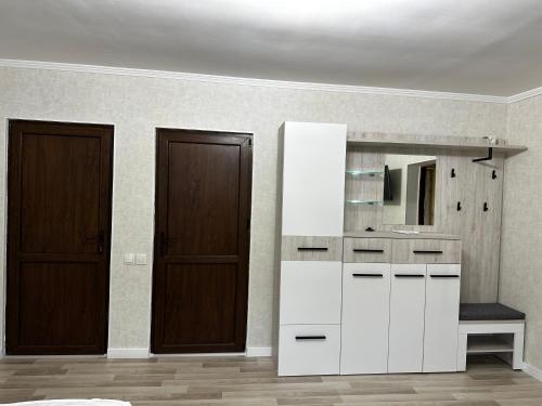 baño con armario blanco y espejo en Apartament Ciocana, en Chişinău