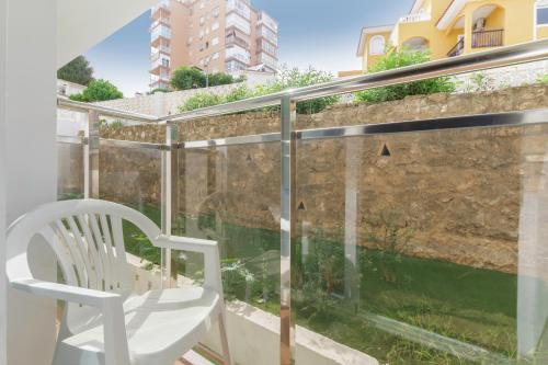 a white chair sitting on a balcony with a window at Hotel Best Siroco in Benalmádena