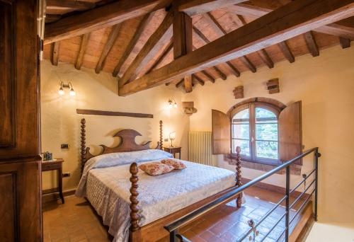 Appartamento la Torretta في رابولانو تيرمي: غرفة نوم بسرير في غرفة بسقوف خشبية