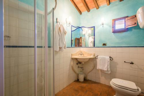 een badkamer met een wastafel, een toilet en een spiegel bij Appartamento la Torretta in Rapolano Terme