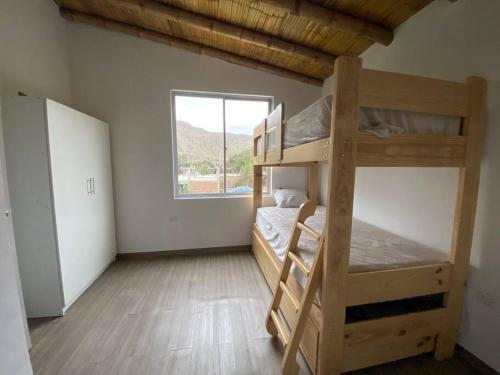 Zimmer mit 2 Etagenbetten und einem Fenster in der Unterkunft Mirador del Paraiso in Lunahuaná