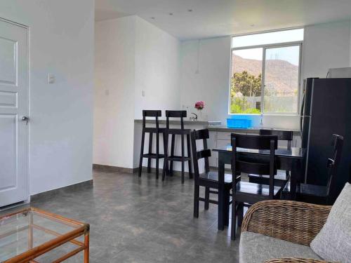 eine Küche mit einem Tisch und Stühlen im Zimmer in der Unterkunft Mirador del Paraiso in Lunahuaná