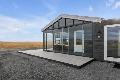 a small house with glass walls and a deck at Selfoss Modern Cabins in Selfoss
