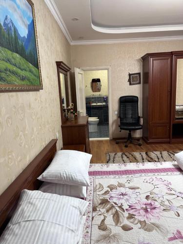 - une chambre avec 2 lits et une chaise dans l'établissement Amanat Hostel Bishkek, à Bishkek