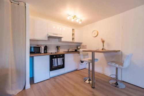 eine Küche mit einem Tisch und Stühlen im Zimmer in der Unterkunft Studio Cosy - plein coeur de Lannion in Lannion
