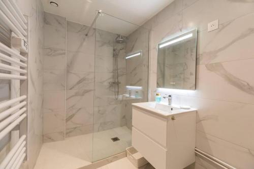 y baño con ducha, lavabo y espejo. en Studio Cosy - plein coeur de Lannion, en Lannion