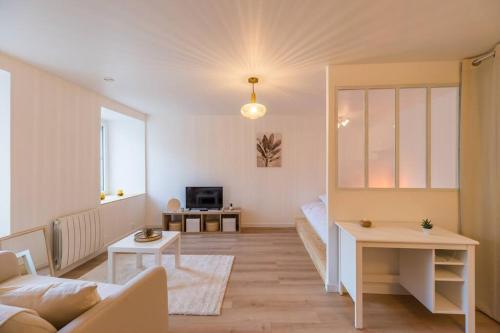 ein Wohnzimmer mit einem Sofa und einem Tisch in der Unterkunft Studio Cosy - plein coeur de Lannion in Lannion