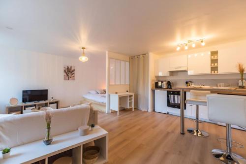 uma sala de estar com um sofá branco e uma cozinha em Studio Cosy - plein coeur de Lannion em Lannion