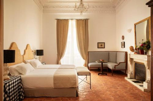 Habitación de hotel con cama y chimenea en Casa Pizarro Hotel en Cáceres