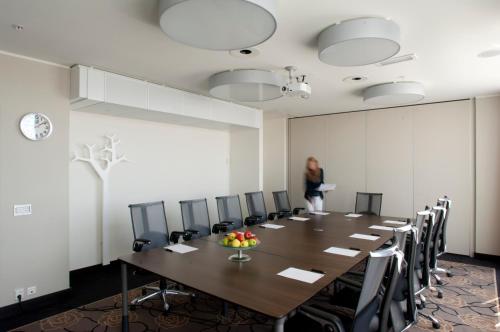 a woman standing in a conference room with a table and chairs at Quality Hotel Fredrikstad in Fredrikstad