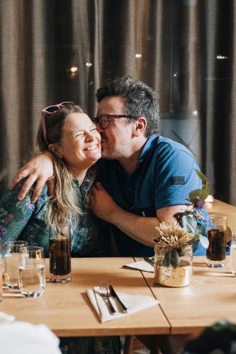 a man and a woman sitting at a table kissing at Quality Hotel Fredrikstad in Fredrikstad