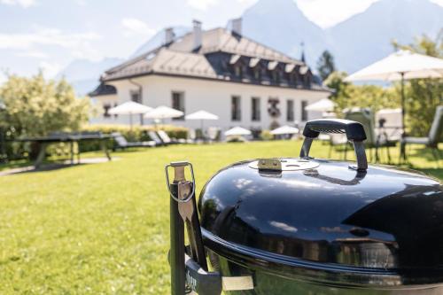 a toaster sitting in the grass in front of a house at Aparthotel Ansitz Felsenheim in Lermoos