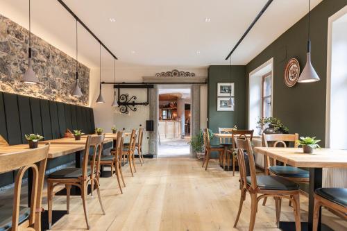 a dining room with wooden tables and chairs at Aparthotel Ansitz Felsenheim in Lermoos
