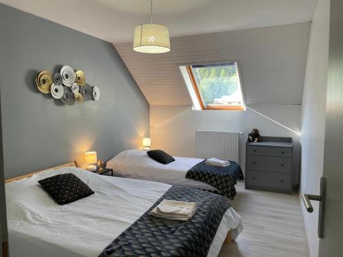 een slaapkamer met 2 bedden en een raam bij Maison L'Aiguille - 2 appartements, 5 chambres et table d'hôtes au pied de la montagne à la station de Laye in Laye