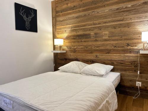 - une chambre avec un lit et un mur en bois dans l'établissement Appartement Standing, Centre Station, 6 pers, Terrasse, Parking, Animaux OK - FR-1-623-107, aux Gets
