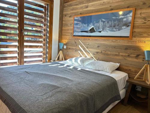 a bedroom with a bed with a wooden wall at Appartement Les Gets, 3 pièces, 6 personnes - FR-1-623-116 in Les Gets