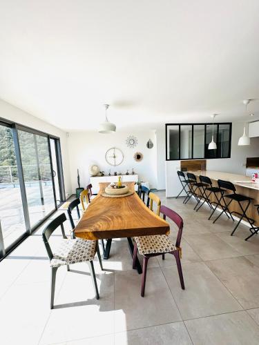 a dining room with a wooden table and chairs at "Villa Cavone" vue mer - piscine privée in Ventiseri
