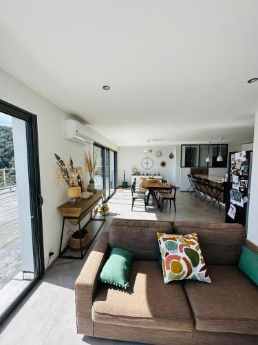 a living room with a couch and a dining room at "Villa Cavone" vue mer - piscine privée in Ventiseri
