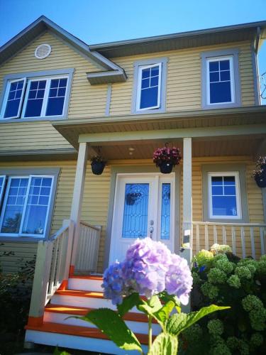 a house with purple flowers in front of it at Maison chaleureuse, énergétique et florale in Sherbrooke