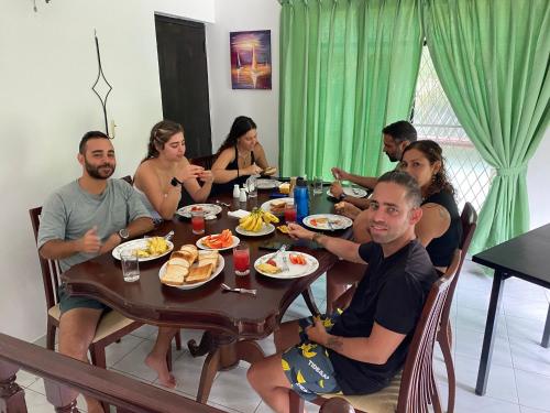 a group of people sitting around a table eating food at Cloud Inn Kandy Homestay - Near Temple of Tooth in Kandy