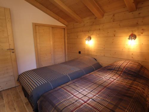 une chambre avec deux lits dans une cabane en rondins dans l'établissement Chalet Neuf Exposé Plein Sud à 600m des Pistes avec Terrasse et Parking - FR-1-623-299, aux Gets