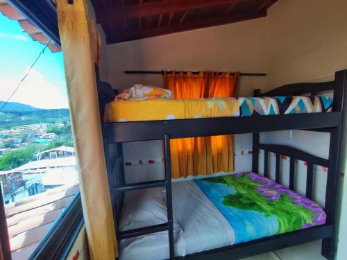 two bunk beds in a room with a window at Mi Techito Curiteño in Curití
