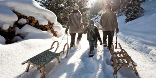 a group of people walking in the snow at Aparthotel Ansitz Felsenheim in Lermoos