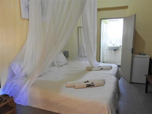 een slaapkamer met een bed met twee handdoeken erop bij Farmhouse Boutique Guest 2 in Outjo