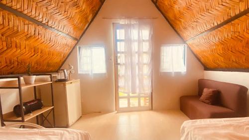 um quarto com uma cama, uma janela e um sofá em Casa Cabana Mabalacat em Mabalacat
