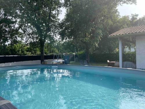 une grande piscine bleue avec un gazebo dans l'établissement Maison au calme avec piscine, à Andernos-les-Bains