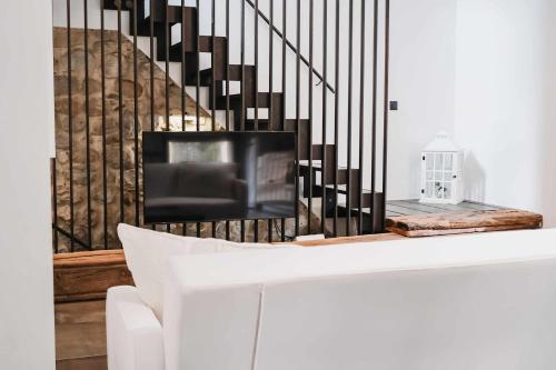 a living room with a tv and a white couch at El Call, Àtic con vistas al puente de Besalú in Besalú