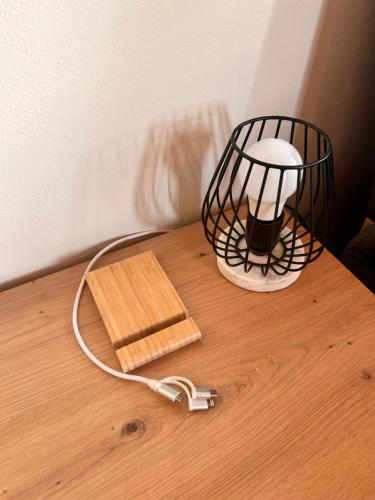 una lampada seduta su un tavolo di legno accanto a un asse di legno di Gallery Apartments a Liberec