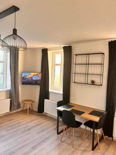 a dining room with a table and chairs and windows at Gallery Apartments in Liberec