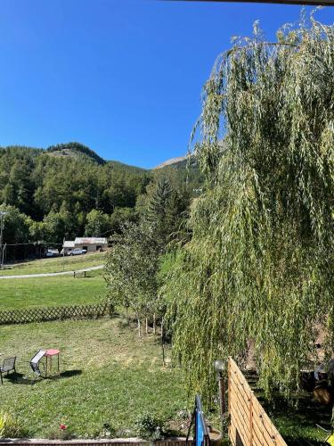 a view of a field with a tree and a fence at Maison L'Aiguille - 2 appartements, 5 chambres et table d'hôtes au pied de la montagne à la station de Laye in Laye