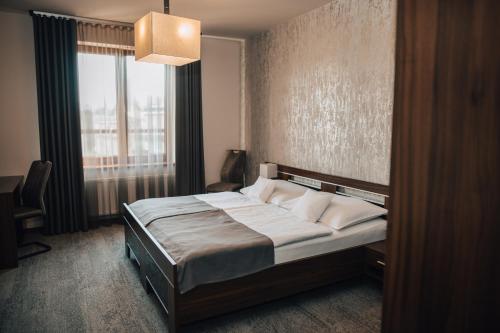 a bedroom with a bed with a large window at Hotel Elegance in Šumperk