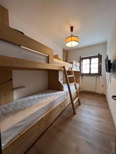 a room with two bunk beds and a window at Casalta by Go New Location in Moena