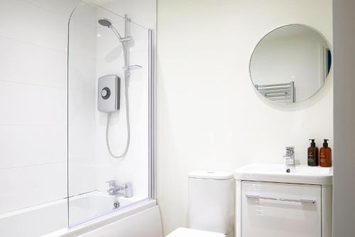 a bathroom with a shower and a sink and a mirror at The Stoop in Scarborough