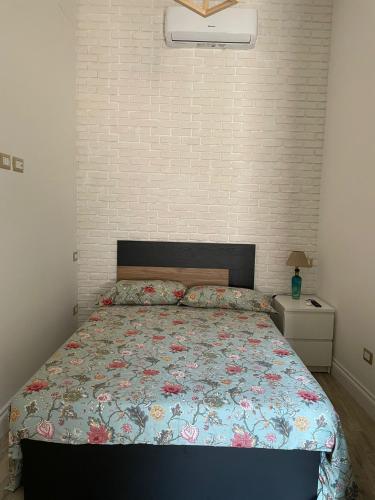 a bedroom with a bed and a brick wall at Casetta Beatrice Tivoli Holiday Home (British) in Tivoli
