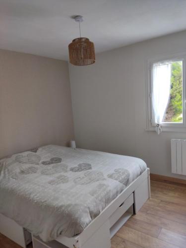een slaapkamer met een bed in een kamer met een raam bij à l'air du Mont in Roz-sur-Couesnon