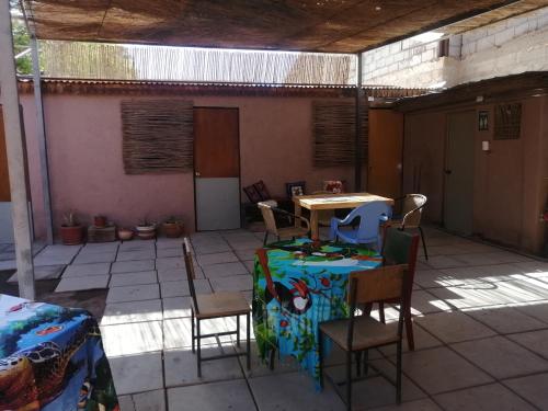 um pátio com uma mesa e cadeiras num quarto em Viajes & Vida km0 em San Pedro de Atacama