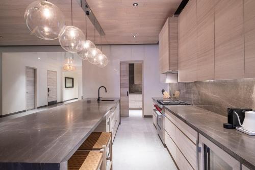 a kitchen with stainless steel counter tops and wooden cabinets at Susurros del Corazón, Auberge Resorts Collection in Cruz de Huanacaxtle