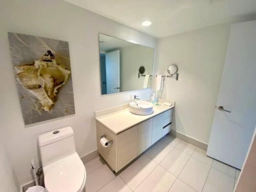 een badkamer met een toilet, een wastafel en een spiegel bij Excellent Aptm Miami Beach 1B/1B in Hallandale Beach