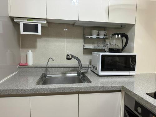 a kitchen with a sink and a microwave at Апартаменты в Хайвилл in Astana