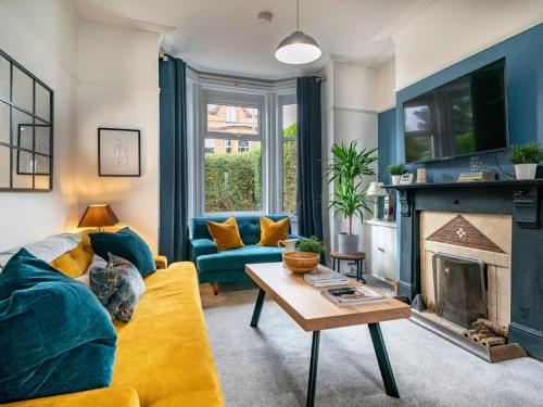 a living room with a yellow couch and a fireplace at Gorgeous 4 Bedroom Home 7 Min from City Centre - Pass the Keys in Belfast