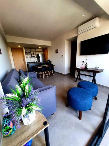 a living room with a blue couch and chairs and a table at Hermoso apartamento nuevo ubicado en zona centrica in Guadalajara
