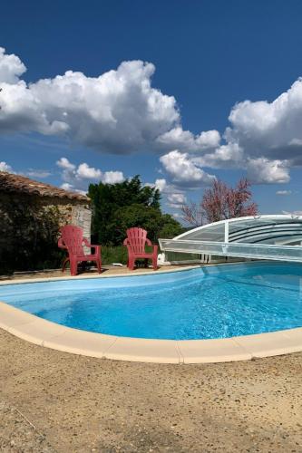 une grande piscine avec deux chaises dans l'établissement Appartement dans ancien mas rénové avec piscine partagée ouverte de 9h30 à 11h30 et de 16h30 à 18h30, à Bessas