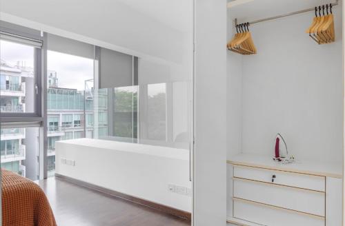 a white bathroom with a tub and a window at Luxury 1Bedroom Apartment in Singapore! in Singapore