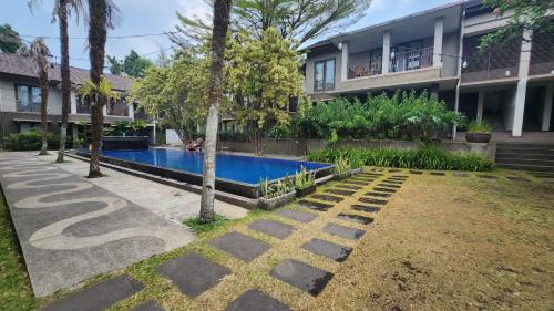 a house with a swimming pool in a yard at Summer Hills Hotel & Villas Bandung in Bandung